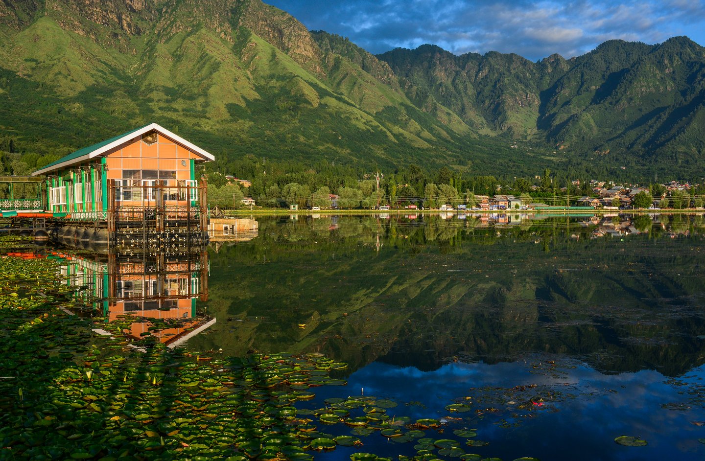 A boathouse on Lake Dal with mountain reflections