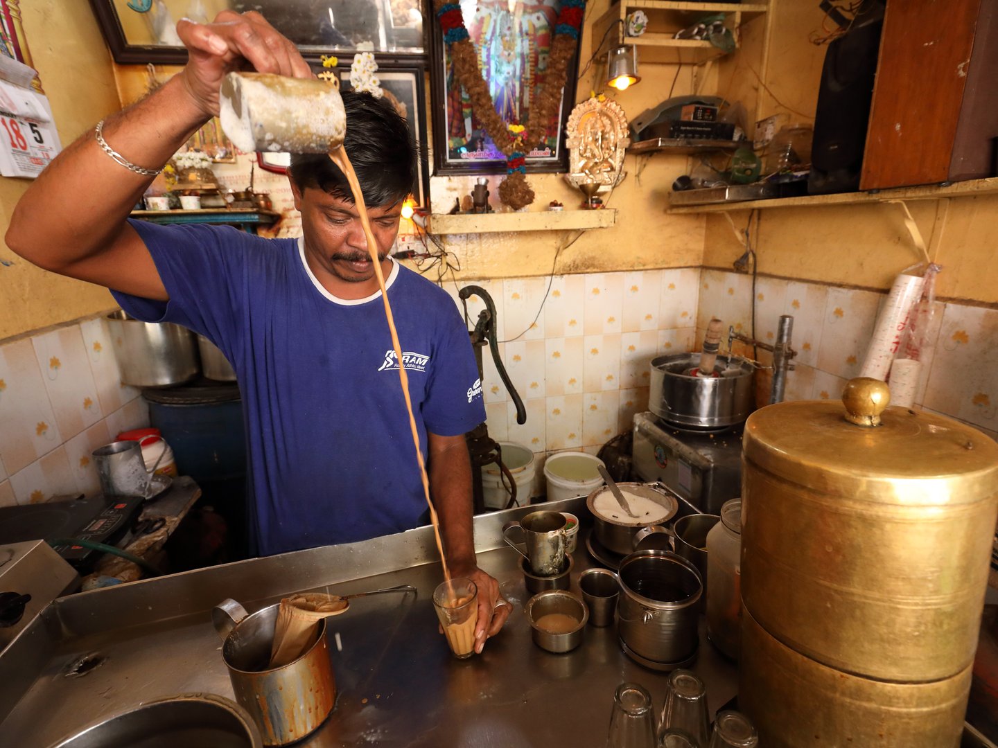 A tea wallah prepares tea in a small traditional stall in Madurai, India.