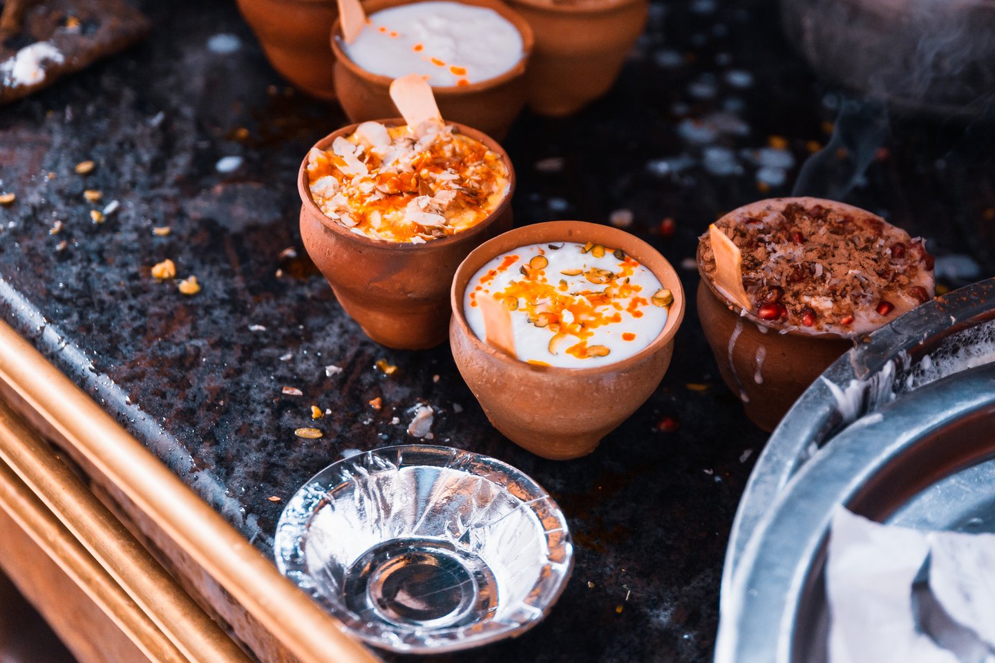 Clay cups filled with lassi and toppings on the street in Varanasi, India