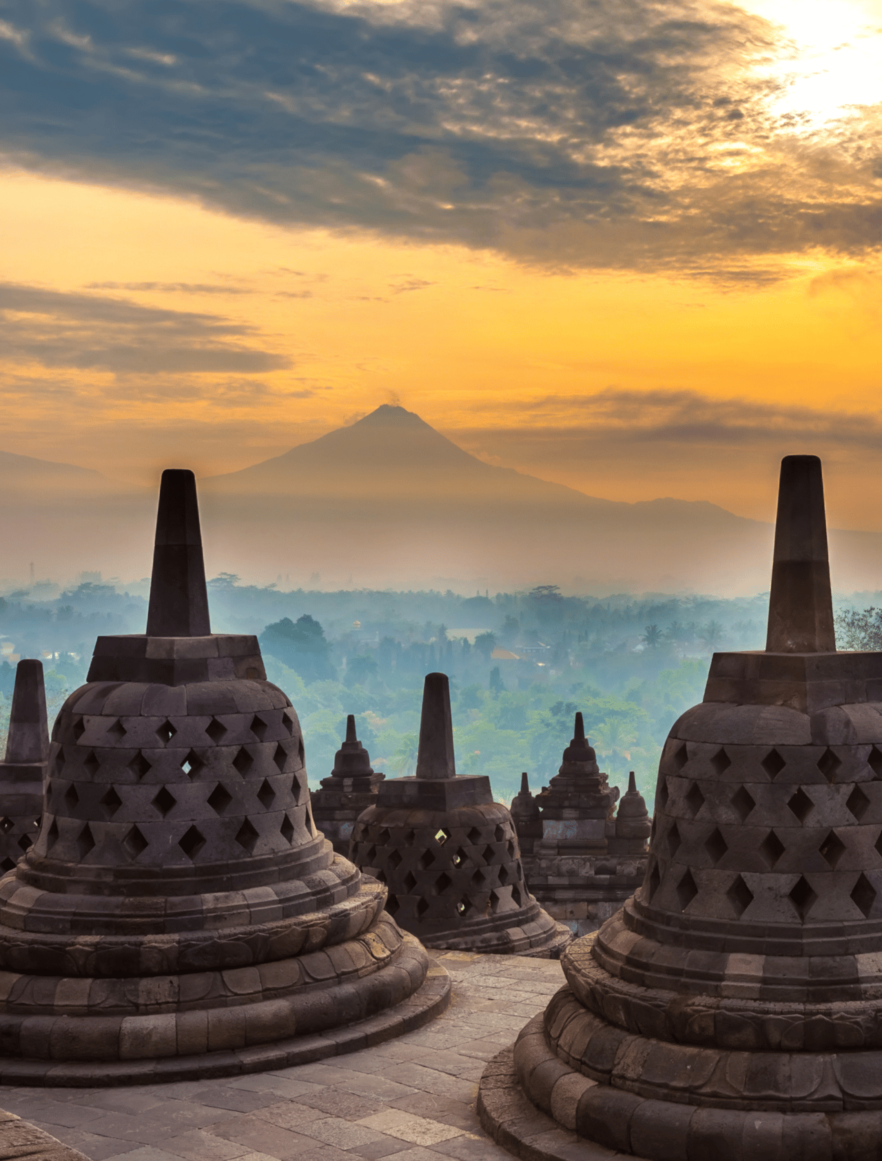 Taman Lumbini park from the height of the temple complex Candi Borobudur at sunrise in the fog.