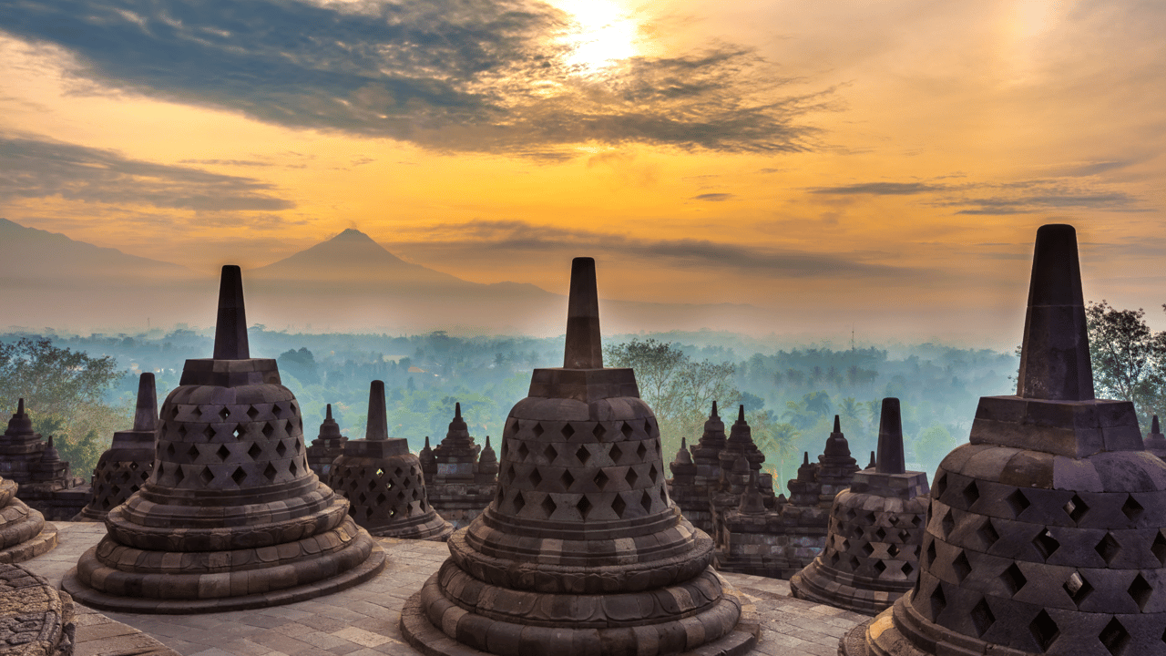 Taman Lumbini park from the height of the temple complex Candi Borobudur at sunrise in the fog.