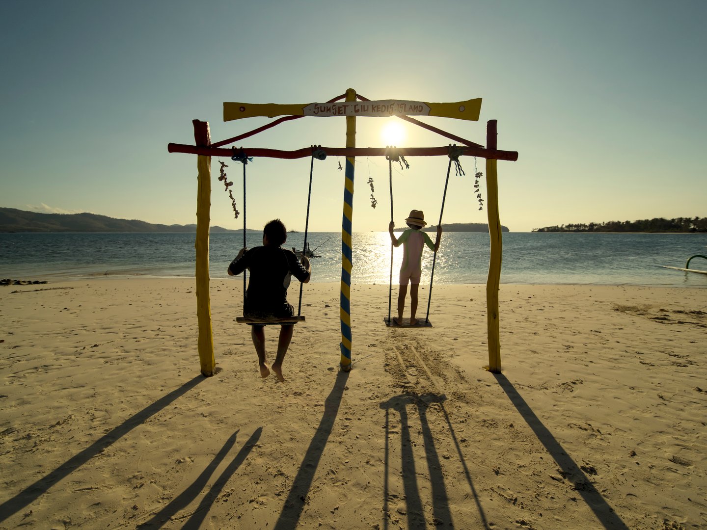 Swinging on the beach at Gili Kedis, Indonesia