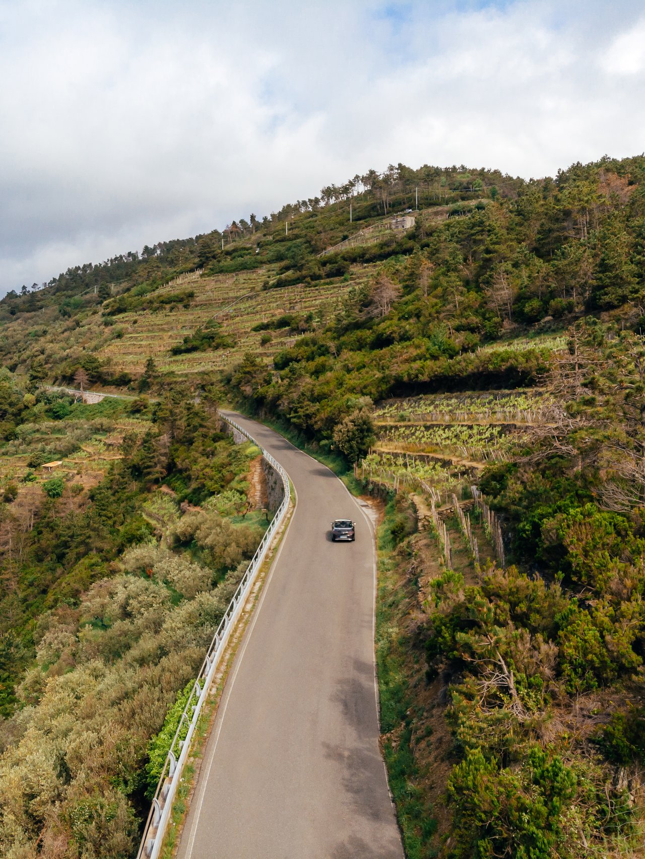 An aerial view of a car driving along a country road in Arezzo, Italy