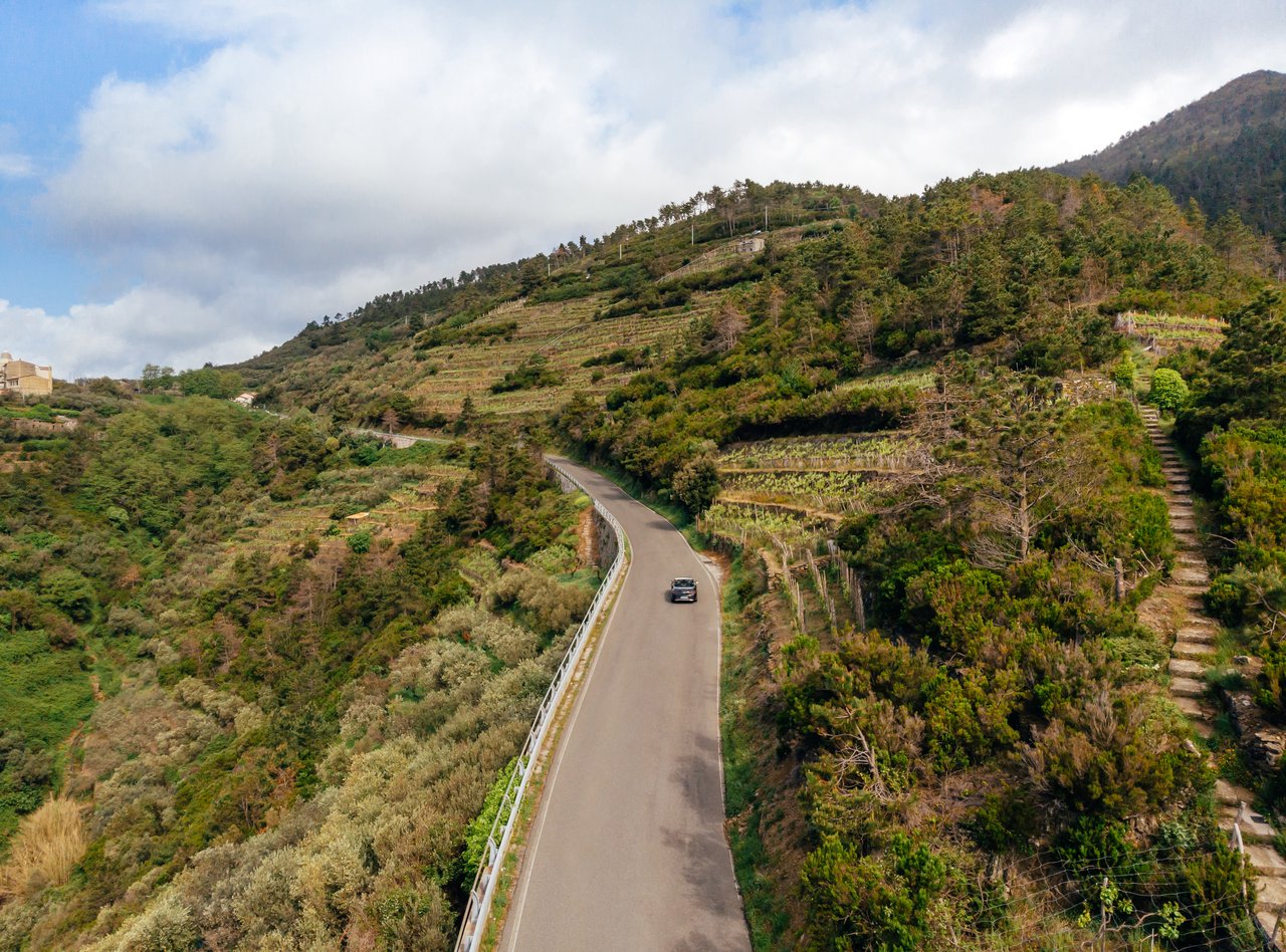 An aerial view of a car driving along a country road in Arezzo, Italy