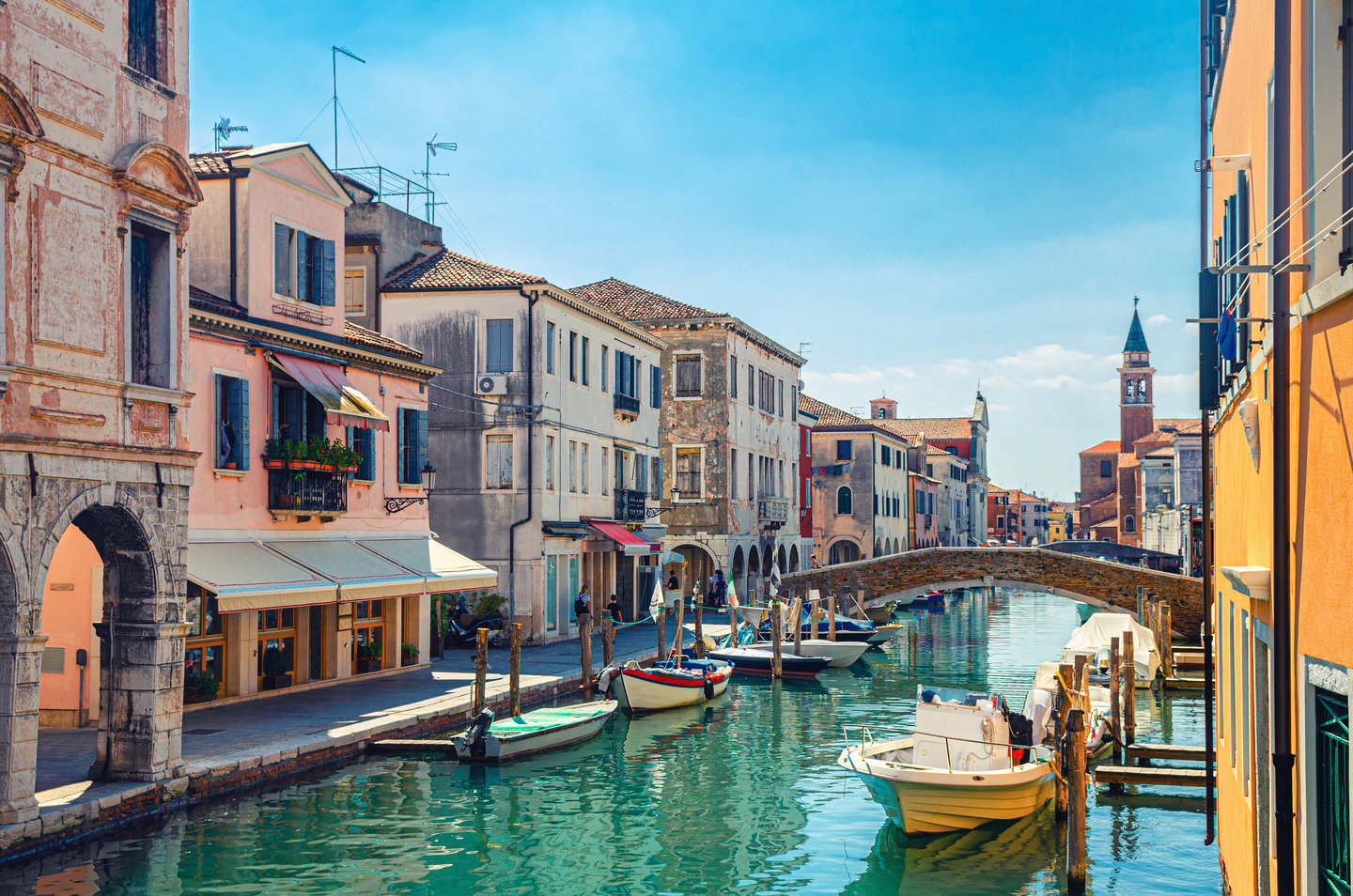 Old buildings in Chioggia along Vena, the narrow water canal with moored multicoloured boats