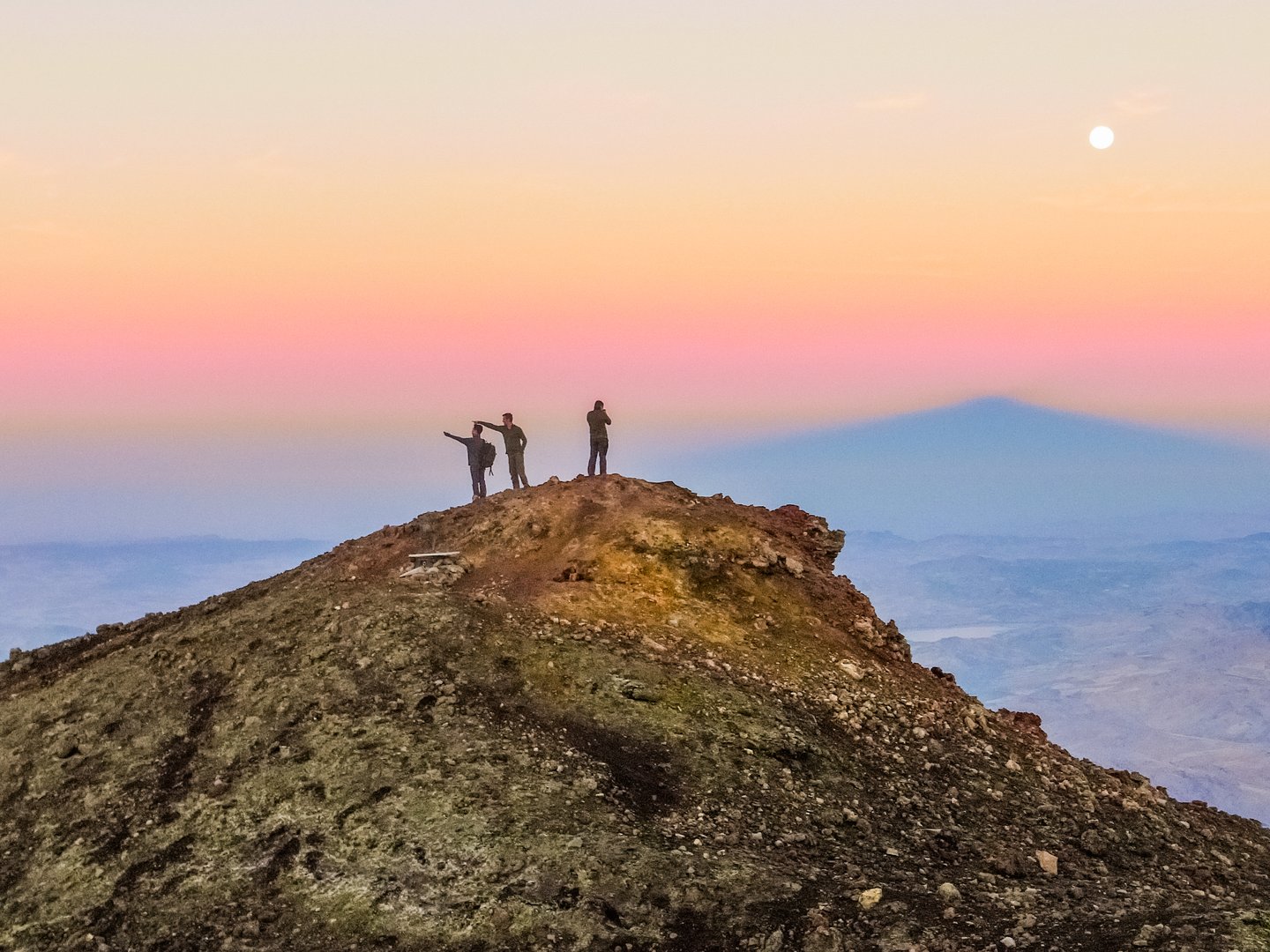 People at the summit of Mount Etna at sunrise.