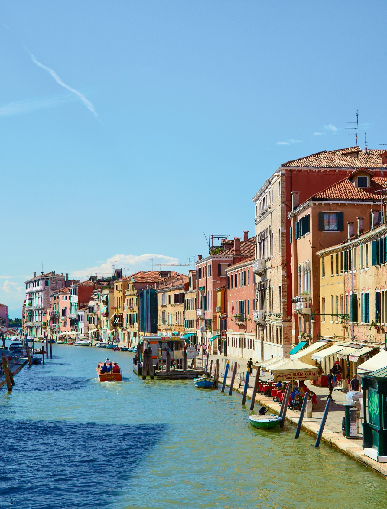 Colourful buildings and restaurants line the Canal Cannaregio from Guglie bridge in Venice, Italy
