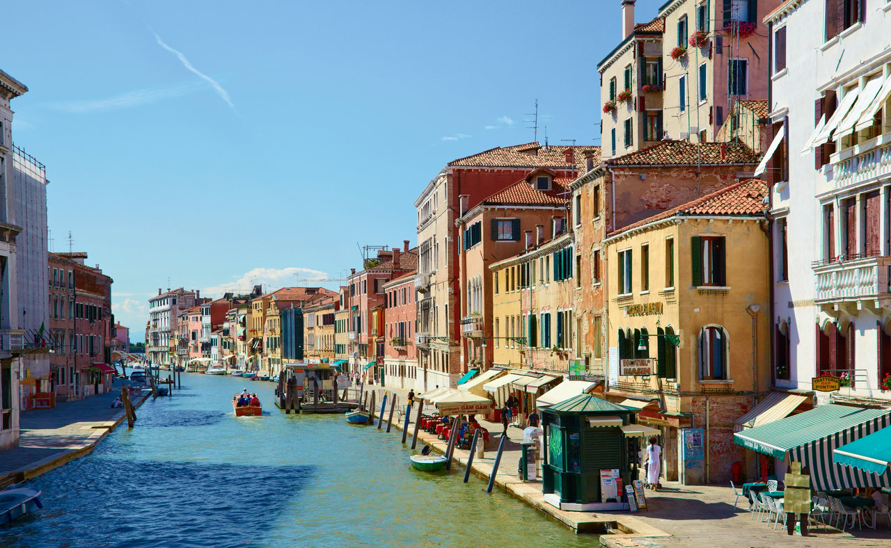 Colourful buildings and restaurants line the Canal Cannaregio from Guglie bridge in Venice, Italy