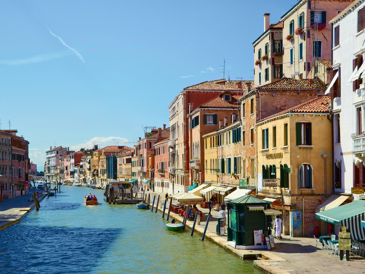Colourful buildings and restaurants line the Canal Cannaregio from Guglie bridge in Venice, Italy