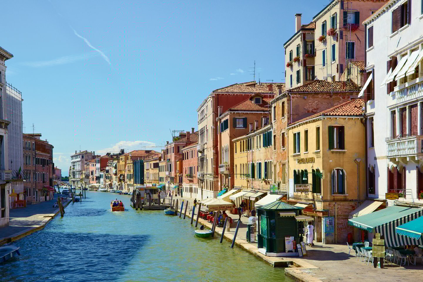 Colourful buildings and restaurants line the Canal Cannaregio from Guglie bridge in Venice, Italy