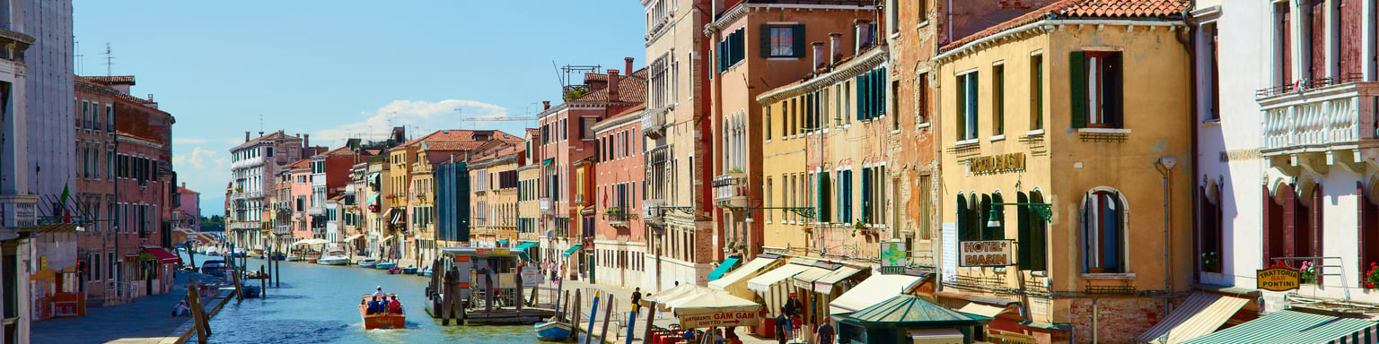 Colourful buildings and restaurants line the Canal Cannaregio from Guglie bridge in Venice, Italy