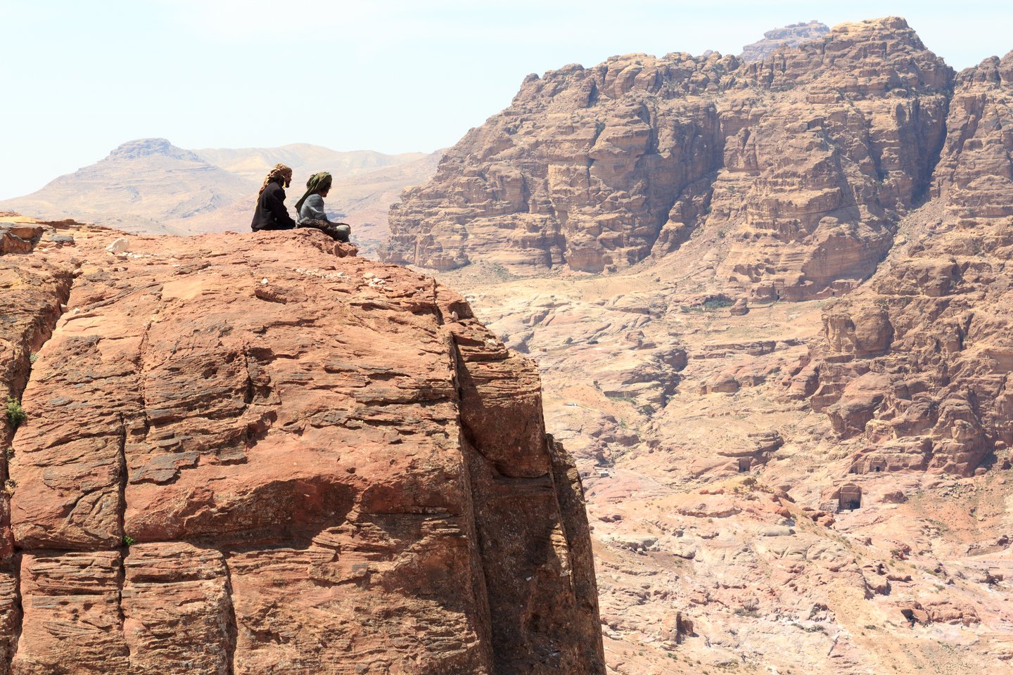 Bedouins sitting on a rock at the High Place of Sacrifice in Petra