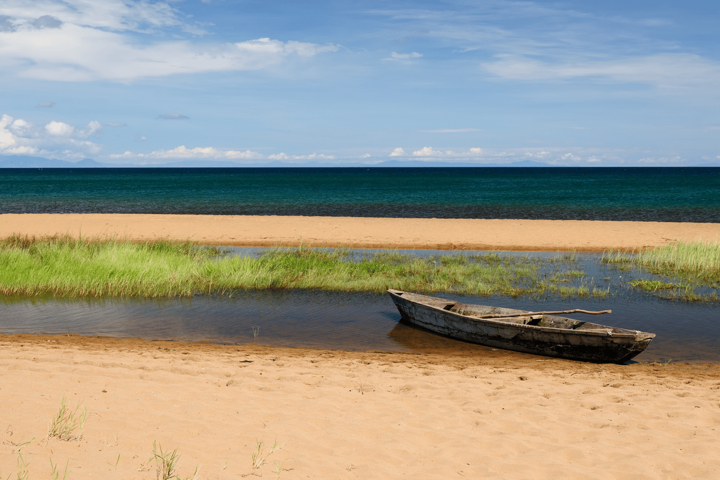 A boat on white sand on the edge of Lake Tanganyika