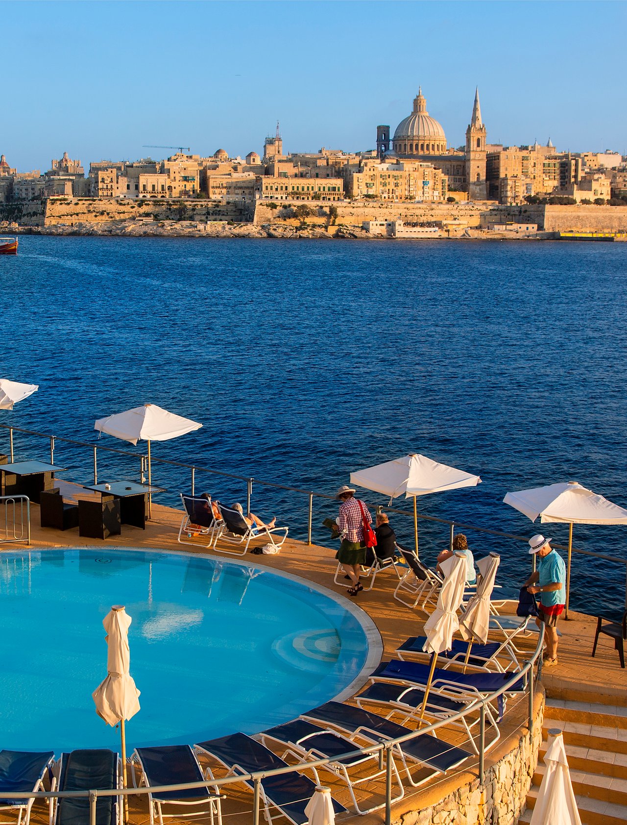 A hotel swimming pool in Sliema with view of Valletta in the distance