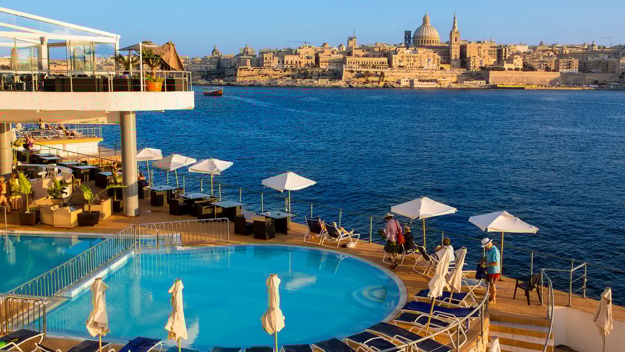 A hotel swimming pool in Sliema with view of Valletta in the distance