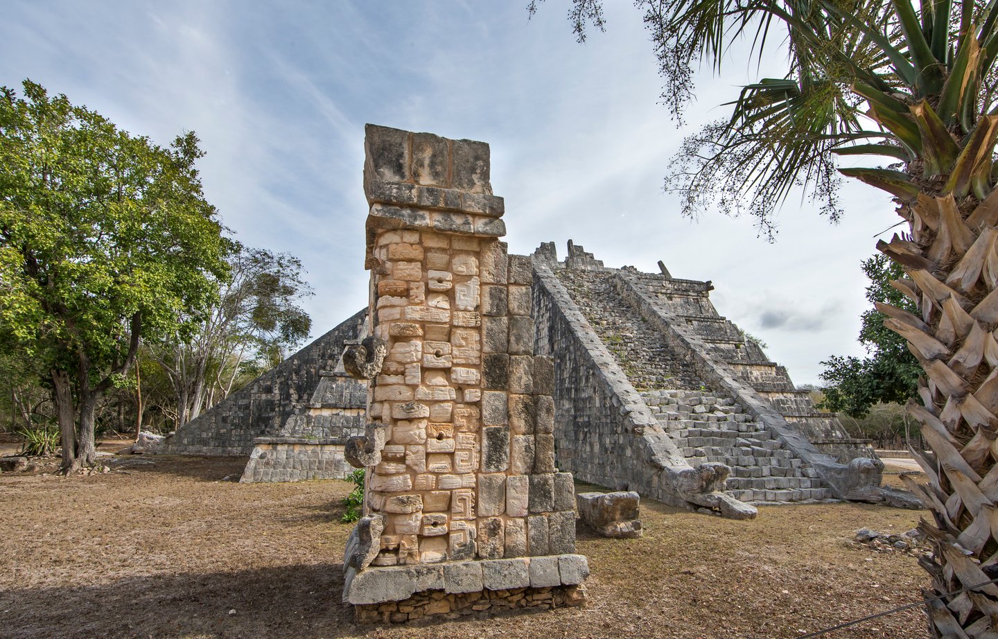 A column in front of a pyramid at Chichen Itza