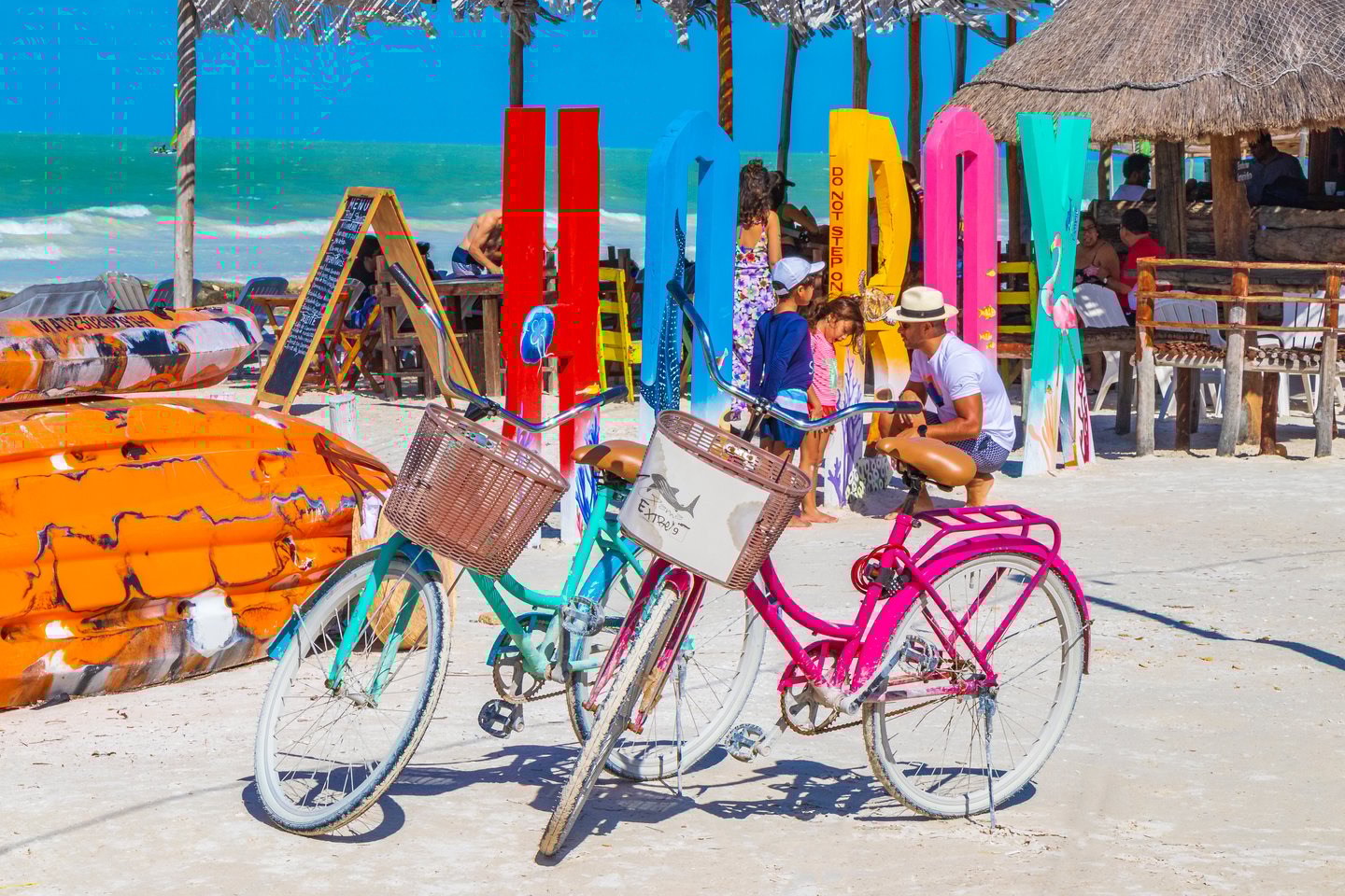 Two bicycles near the colourful Holbox sign