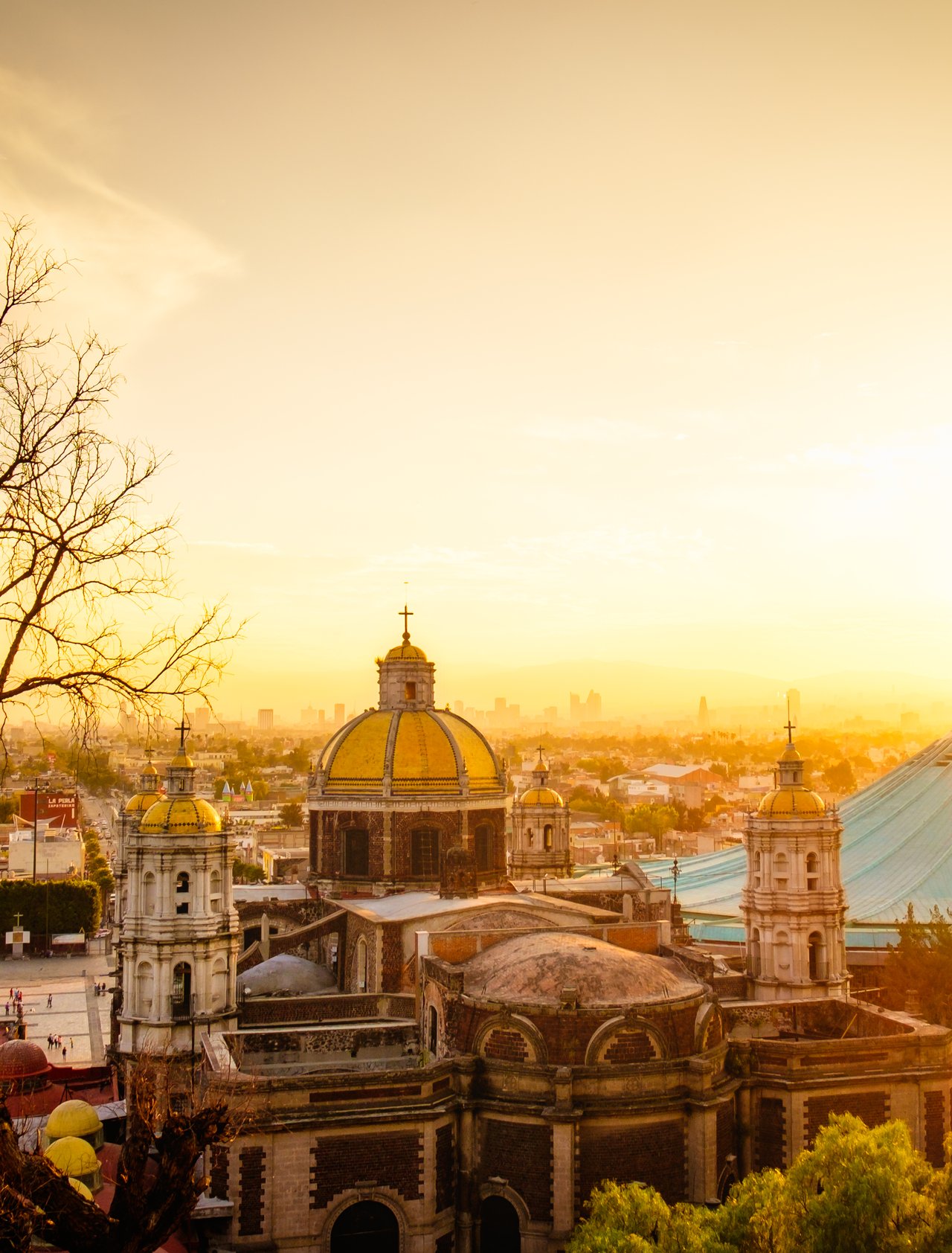 Scenic view at Basilica of Guadalupe with Mexico city skyline at sunset