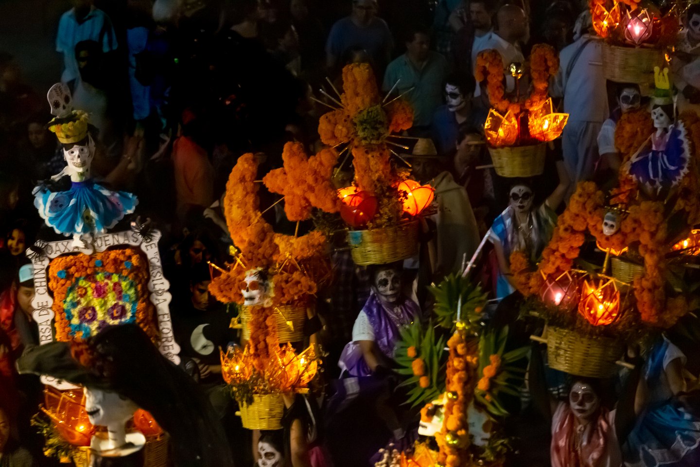 Women dancing in a nighttime Day of the Dead parade in Oaxaca, Mexico