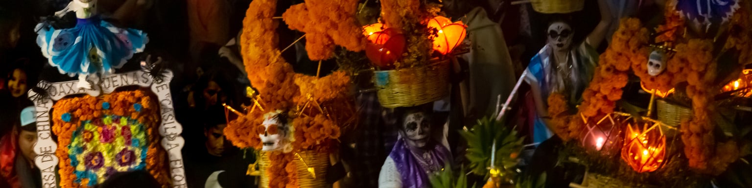Women dancing in a nighttime Day of the Dead parade in Oaxaca, Mexico