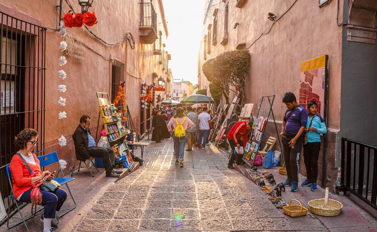 Tourists and locals admiring art works lining the streets at an art fair in Santiago de Queretaro