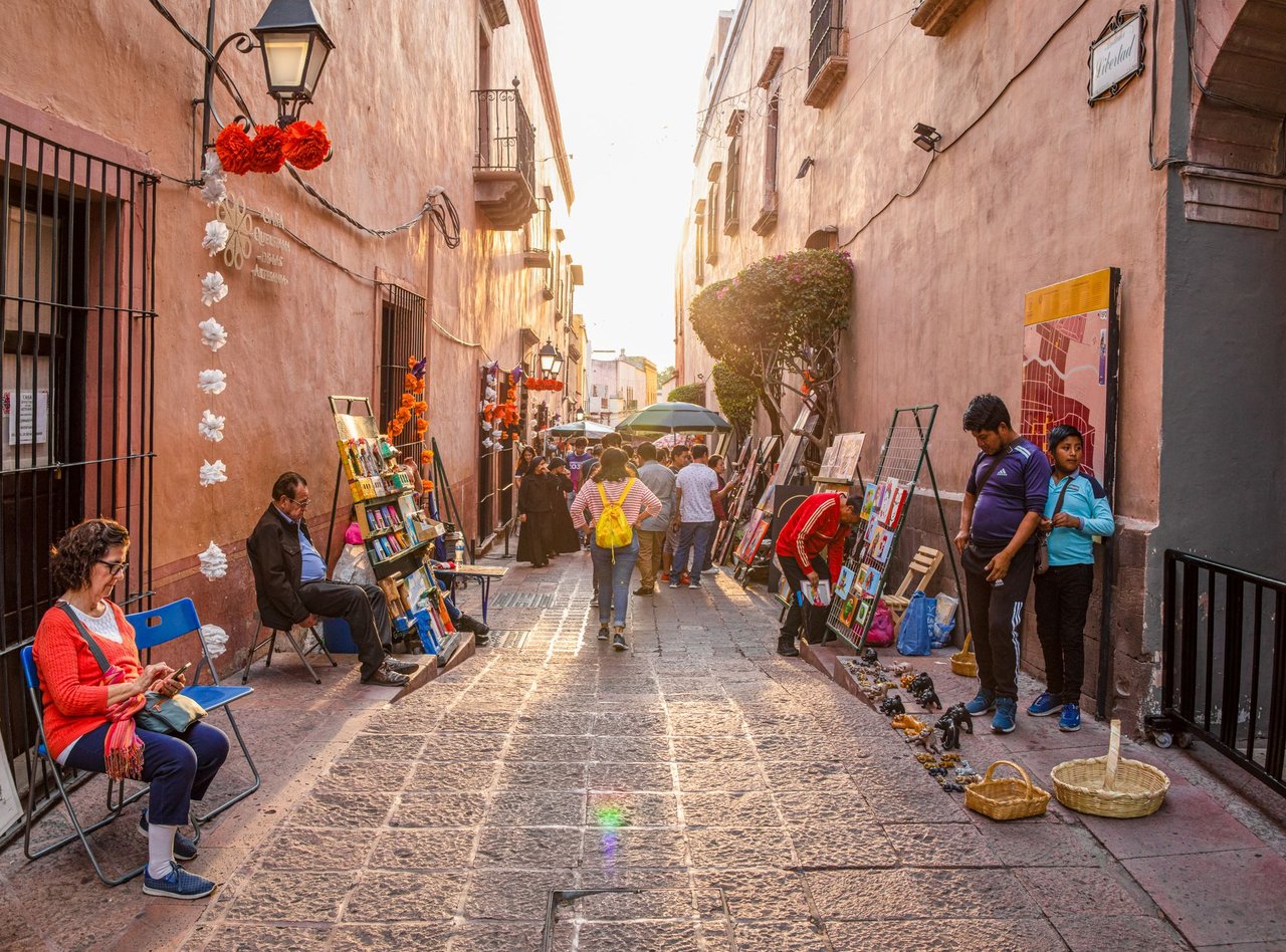 Tourists and locals admiring art works lining the streets at an art fair in Santiago de Queretaro