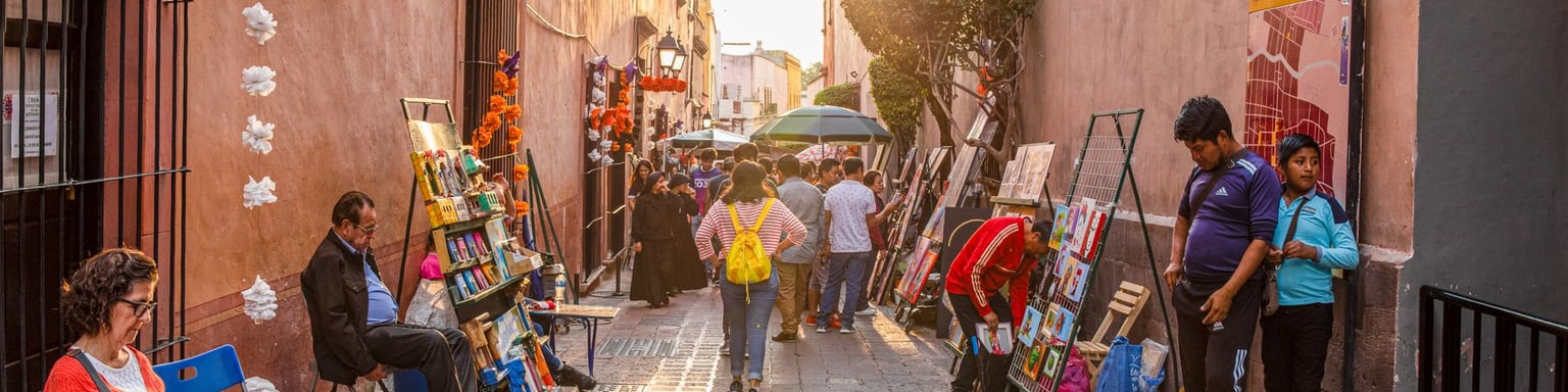Tourists and locals admiring art works lining the streets at an art fair in Santiago de Queretaro