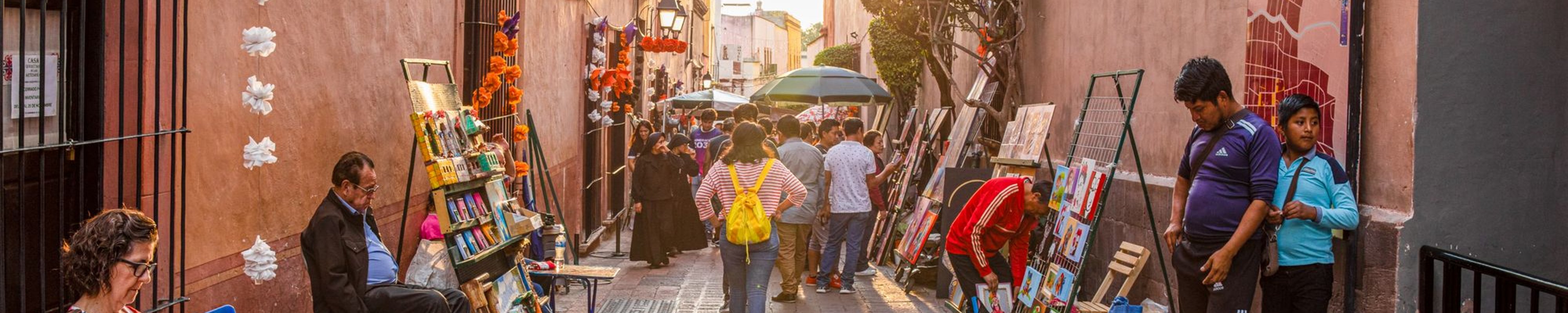 Tourists and locals admiring art works lining the streets at an art fair in Santiago de Queretaro