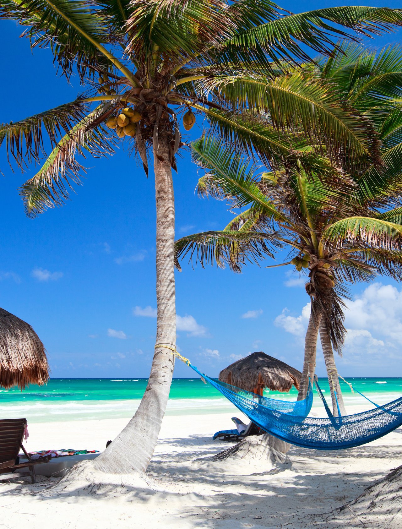 Loungers and a hammock on a sandy beach in Tulum