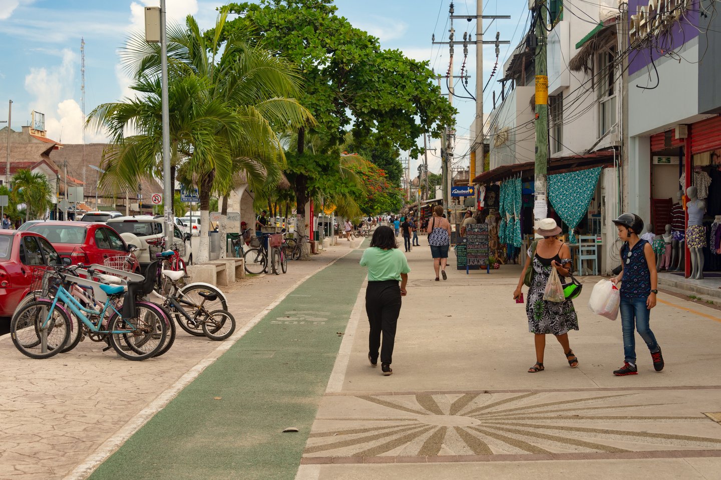 People walking on the sidewalk on Avenida Tulum.