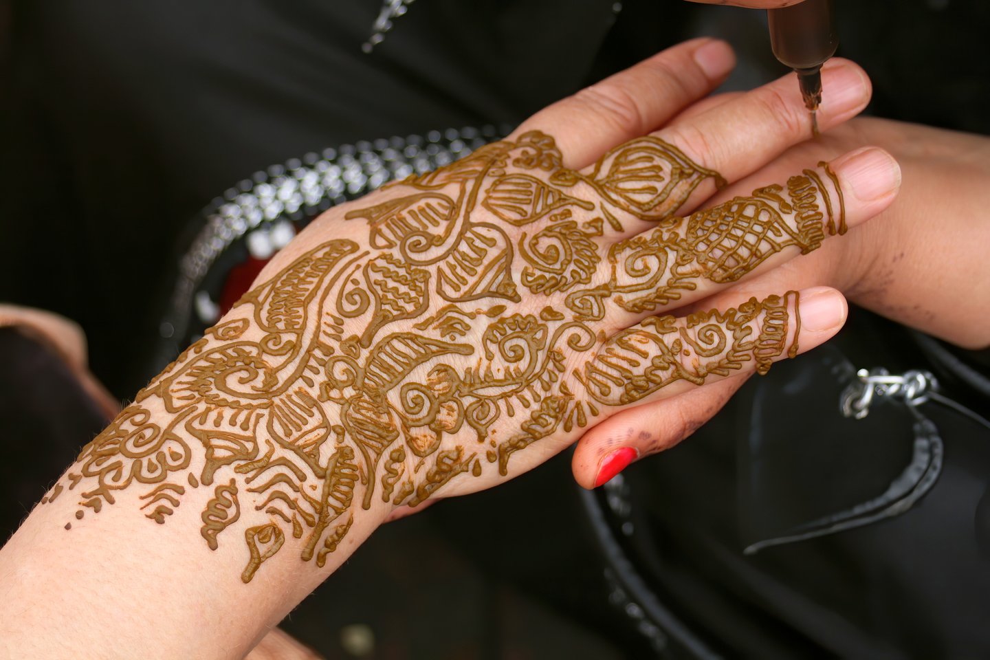 Henna being applied to a woman`s hand in Jemma el-Fna square in Marrakech in Morocco.