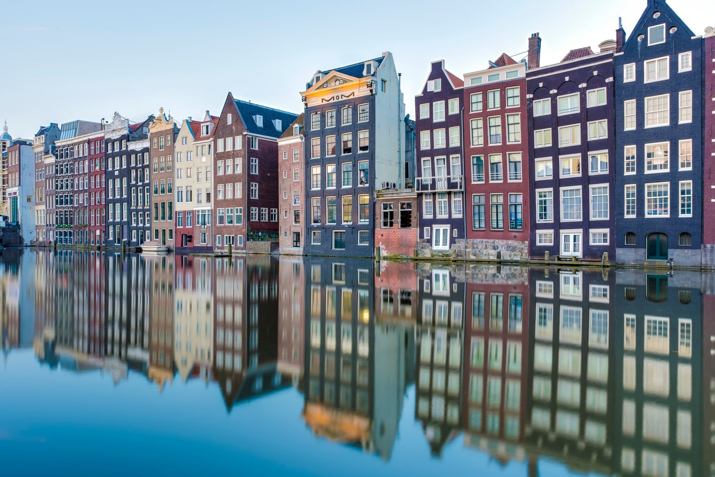  Reflections of buildings in the Damrak canal in Amsterdam, Netherlands