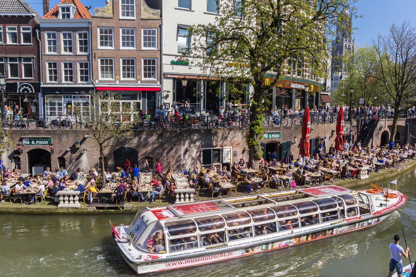 A tourist boat on a canal lined with restaurants