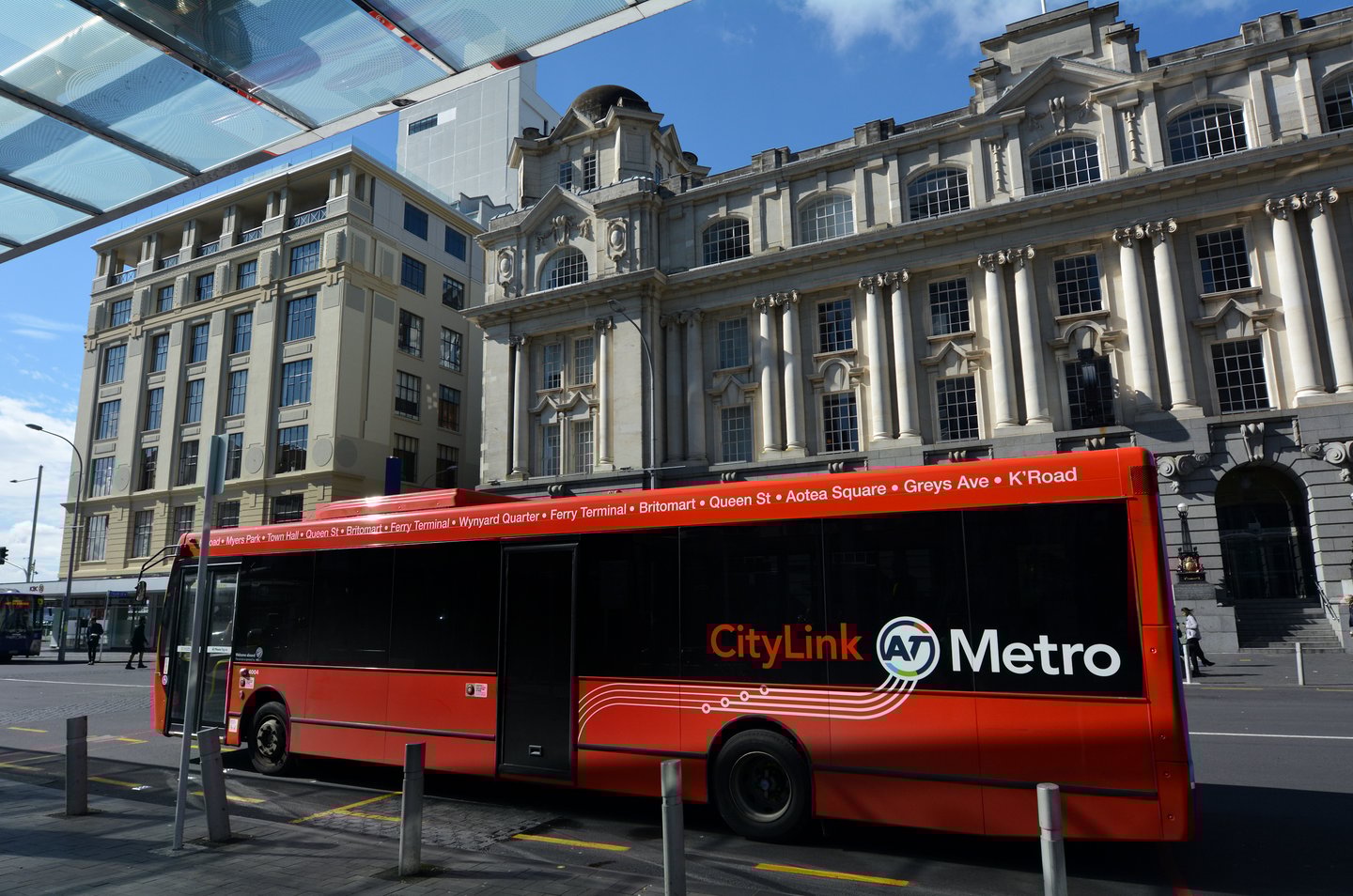 A red Auckland Transport bus in Auckland