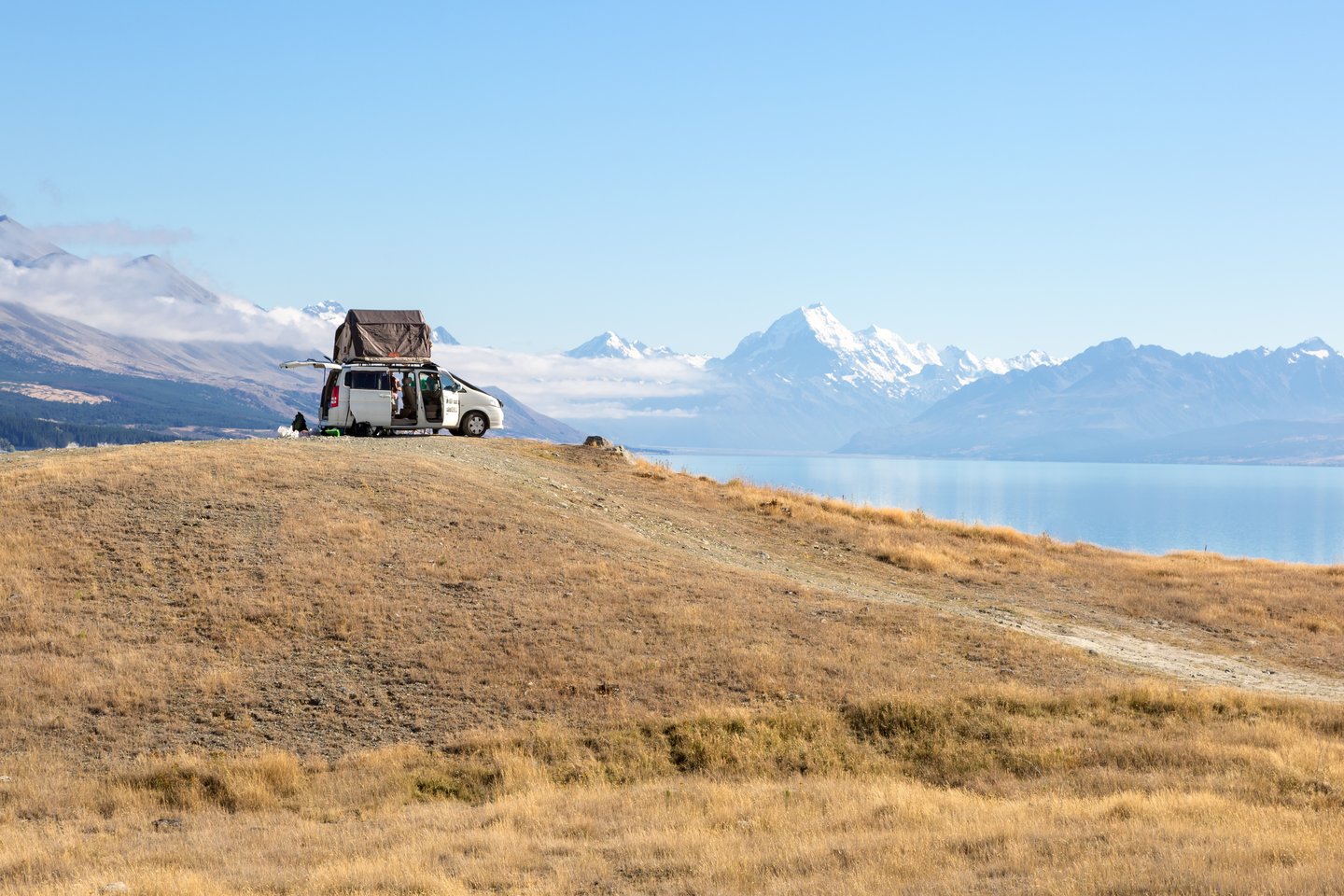 A campervan parked on a hill with mountains in the distance