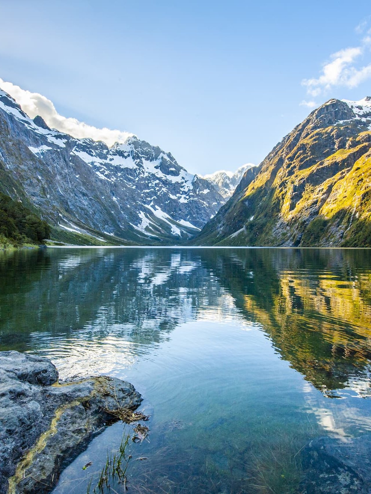 Peaks of Darran Mountains reflecting in Lake Marian, Fiordland national park, New Zealand