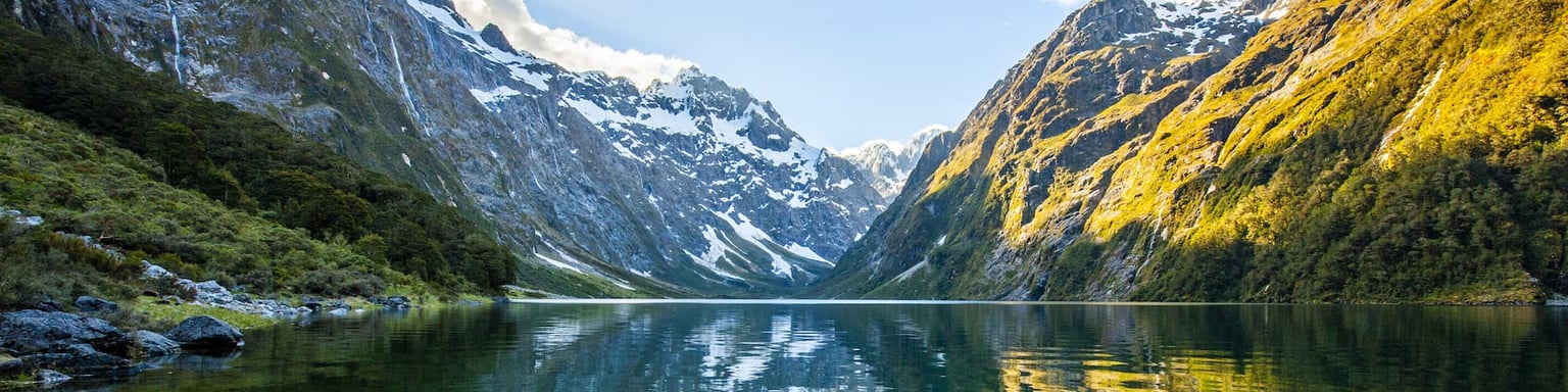 Peaks of Darran Mountains reflecting in Lake Marian, Fiordland national park, New Zealand