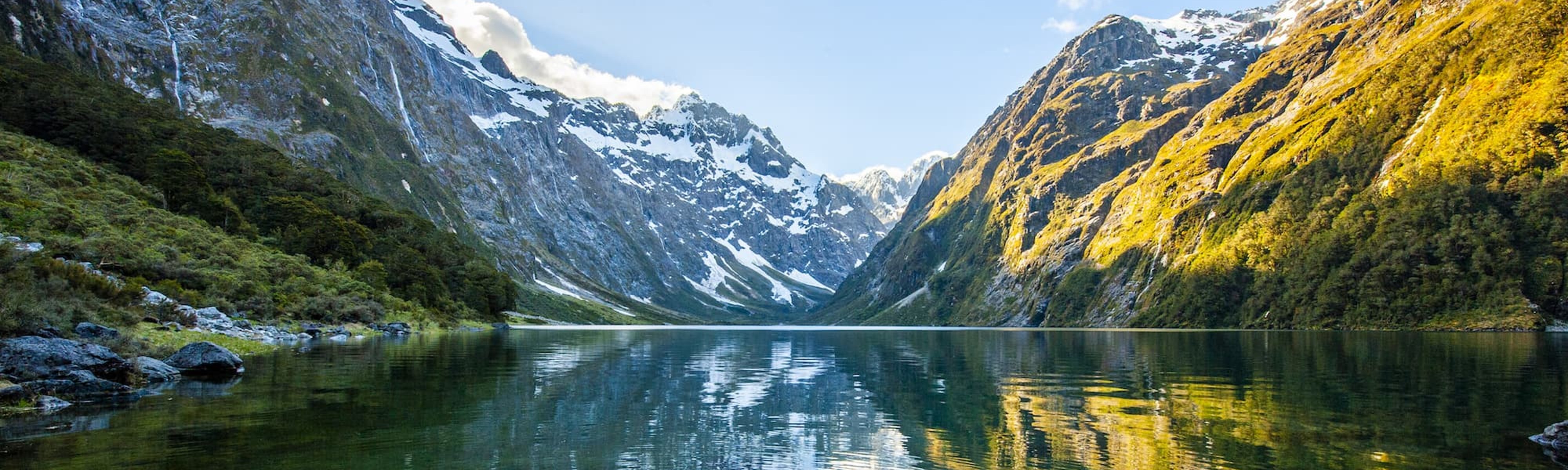 Peaks of Darran Mountains reflecting in Lake Marian, Fiordland national park, New Zealand