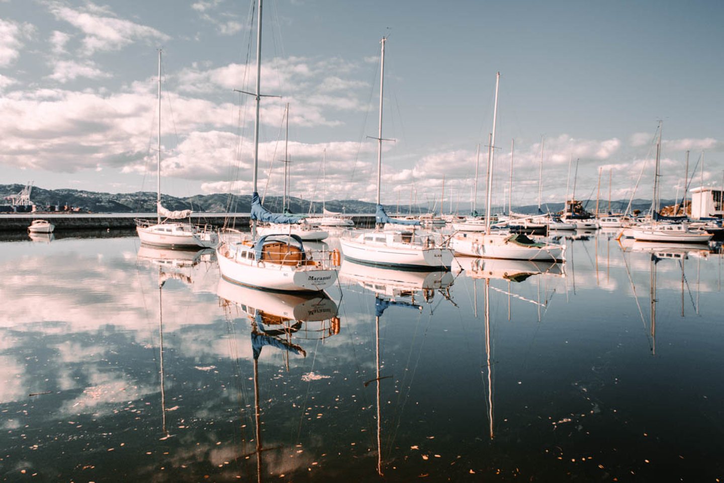 Boats reflected in the water at Wellington harbour, New Zealand