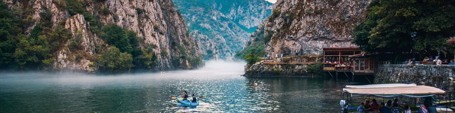 Canyon Matka near Skopje, with people kayaking and magical foggy scenery with calm water