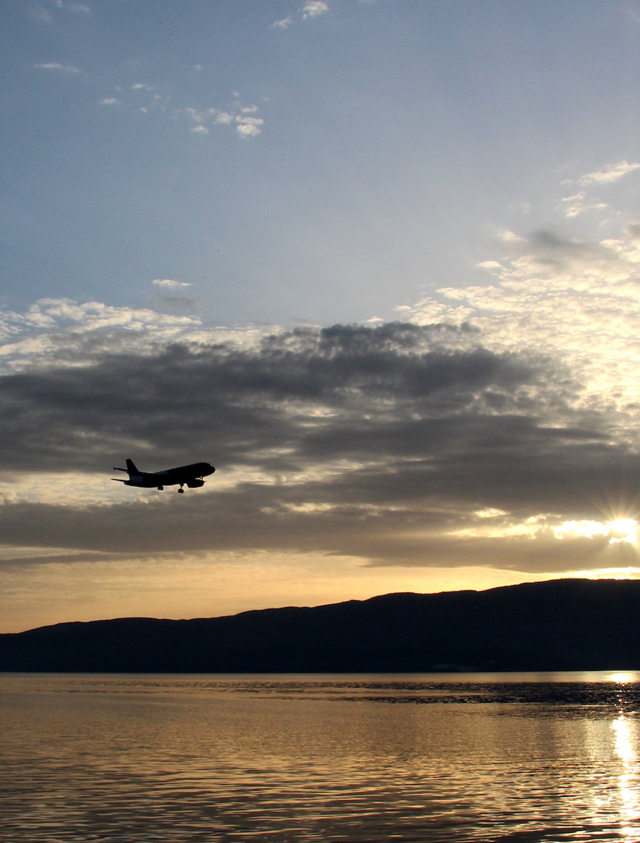 A plane flying above Lake Ohrid at sunset