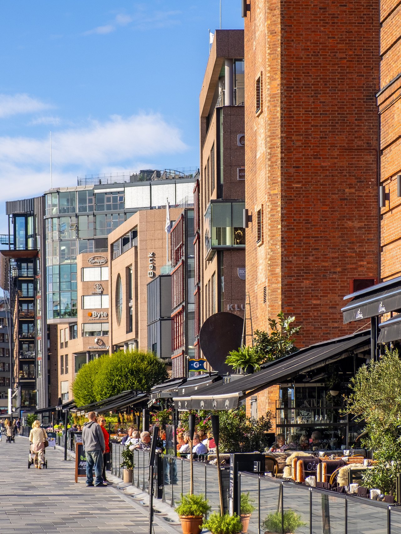 People walking along the waterfront in Oslo's Aker Brygge district.
