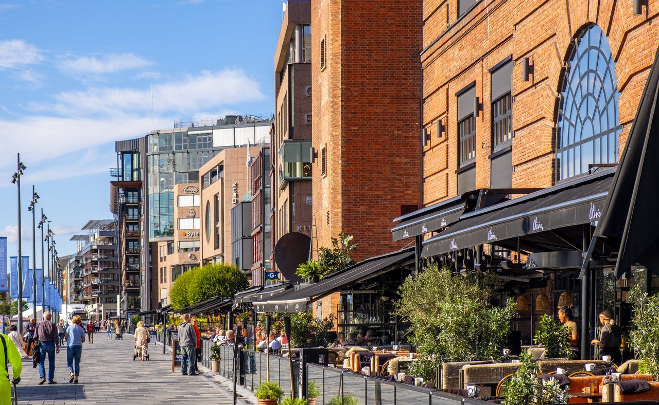 People walking along the waterfront in Oslo's Aker Brygge district.