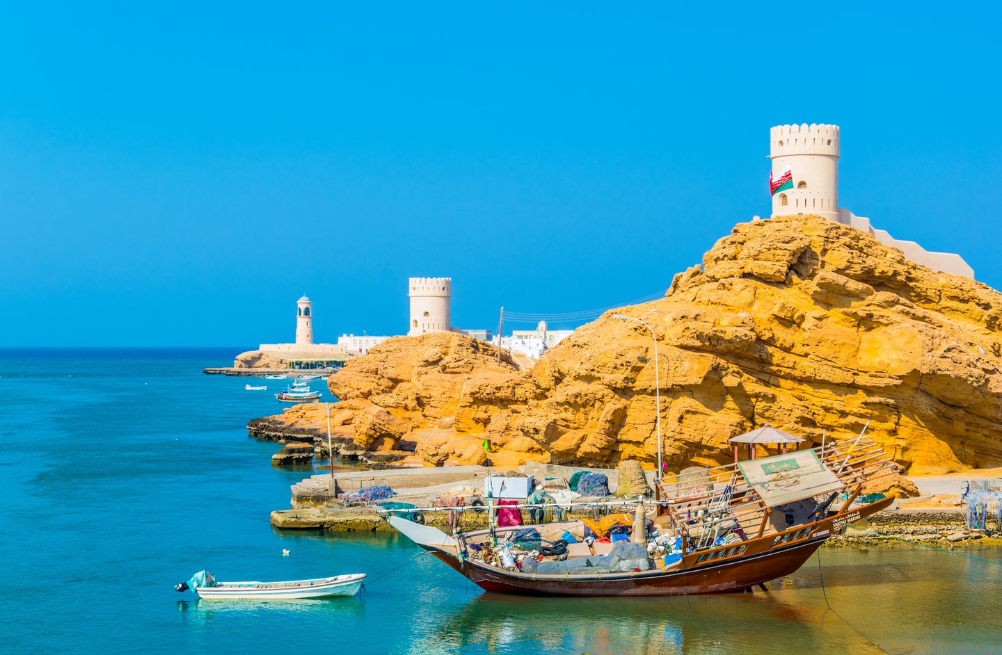 View of the Al Ayjah town, two watchtowers and a dhow under repair from the Khor Al Batah bridge in Sur, Oman