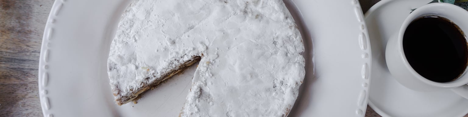 Panforte on plate next to cup of espresso