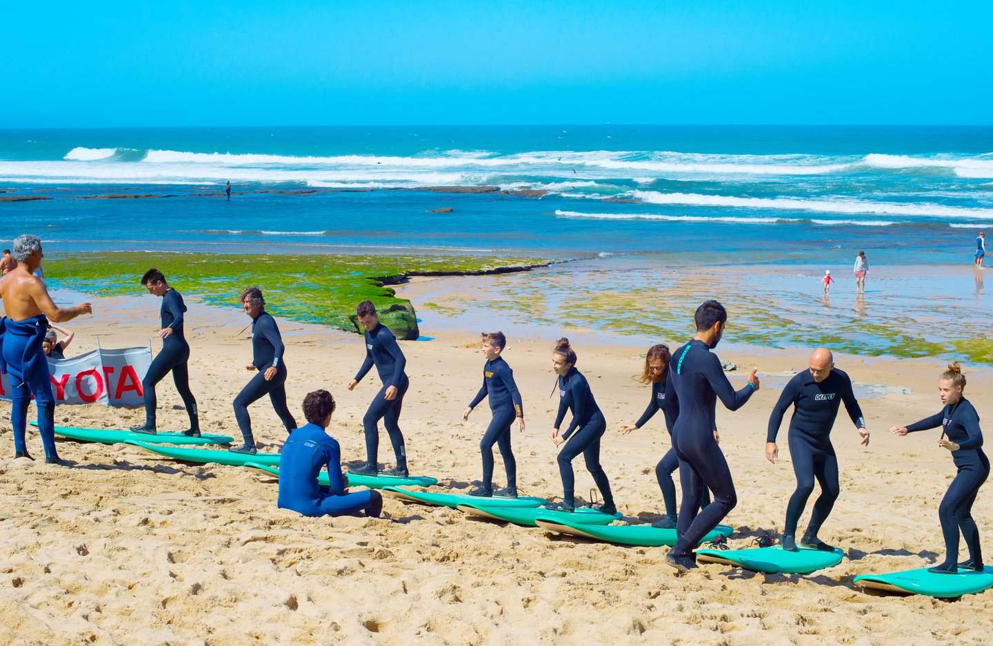 Surfers lined up on the beach in Ericeira, Portugal