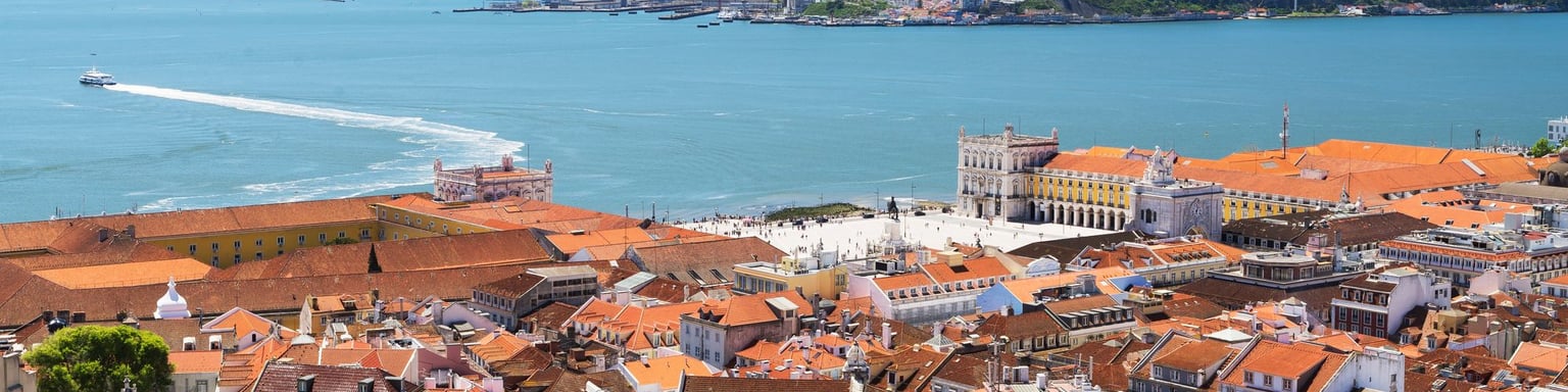 Looking down at Commerce Square and the red roofs of Lisbon with the water in the distance