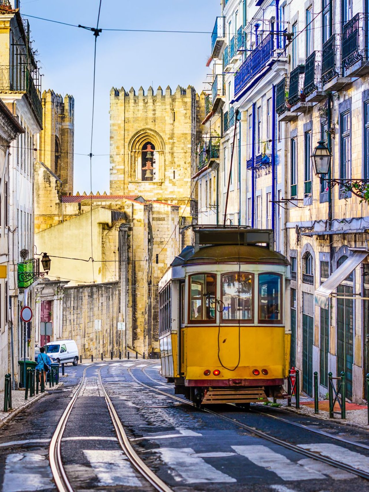 An iconic, yellow tram surrounded by historic buildings in Lisbon, Portugal.