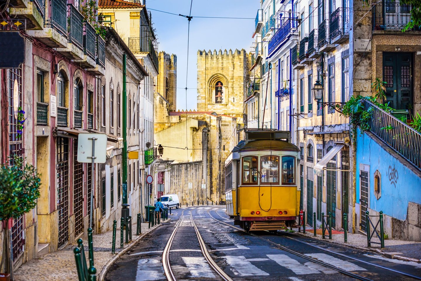 An iconic, yellow tram surrounded by historic buildings in Lisbon, Portugal 