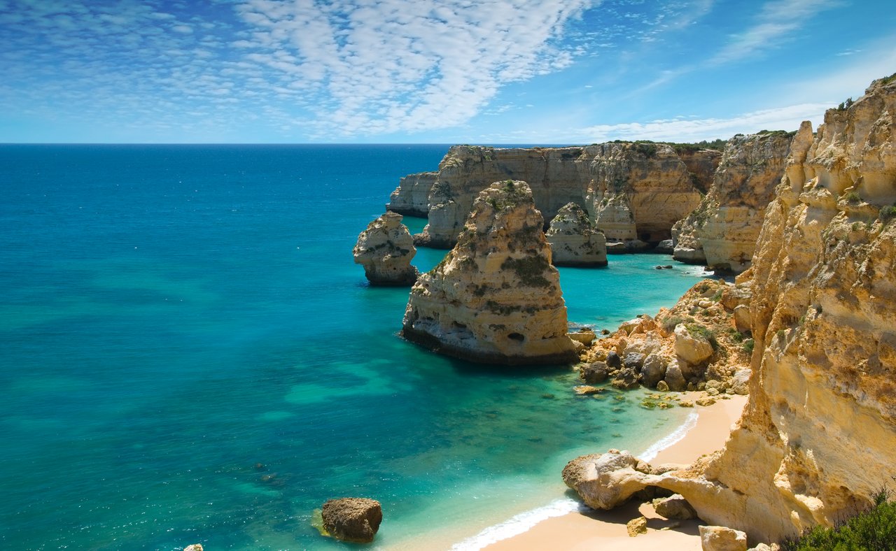 Rocks and a white, sandy beach in Marinha Cove, Portugal